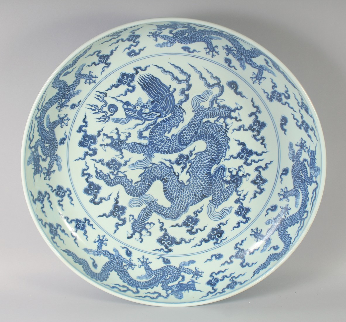 A VERY LARGE CHINESE BLUE AND WHITE PORCELAIN DRAGON DISH, with a large central dragon and the