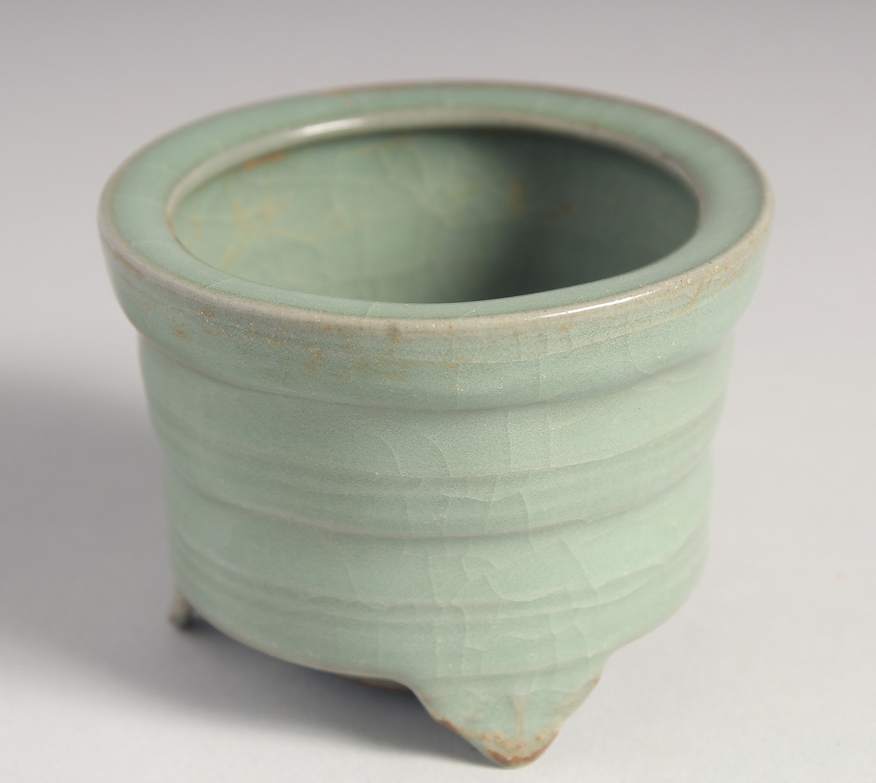 A SMALL CHINESE CELADON GLAZE TRIPOD INCENSE BURNER, 8.5cm diameter.