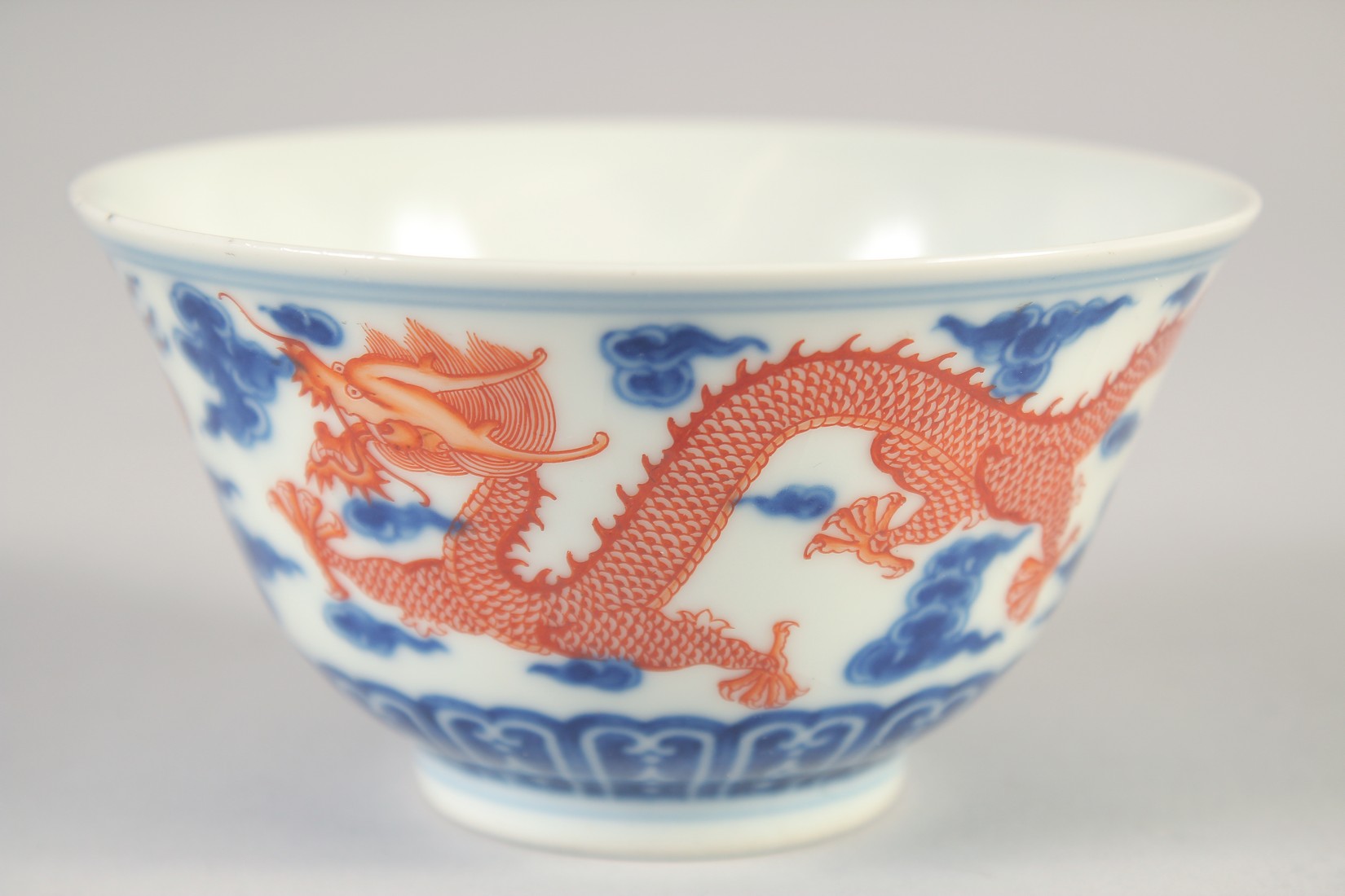 A CHINESE BLUE, WHITE AND IRON RED BOWL, with dragons and stylised clouds, Xuantong mark to base, - Image 3 of 7