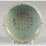 A CHINESE CELADON BOWL, with incised calligraphy, 19cm diameter.