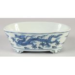 A CHINESE BLUE AND WHITE PORCELAIN PLANTER, with dragons and stylised clouds, raised on four feet,