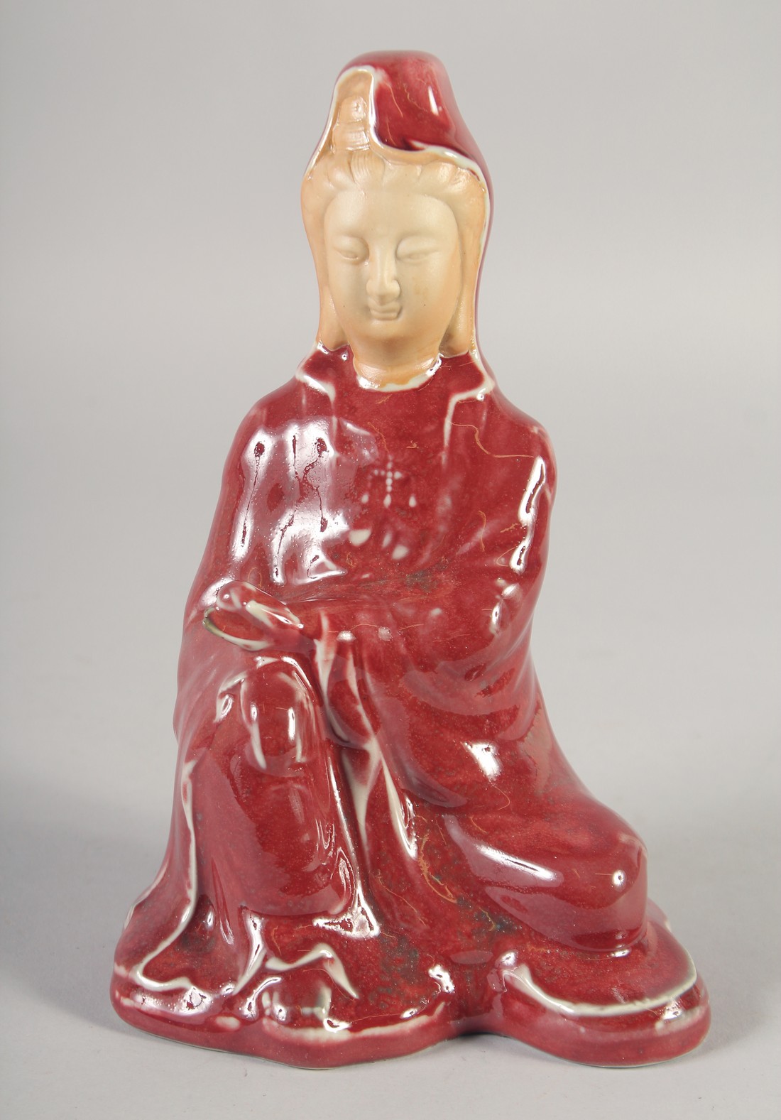 A CHINESE COPPER RED GLAZE PORCELAIN FIGURE, 21cm high.