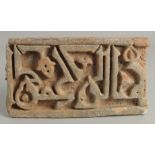 AN ISLAMIC STONE TILE WITH KUFIC SCRIPT, 26cm x 14.5cm.