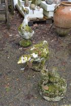 Two garden ornaments modelled as geese together with another ornament.
