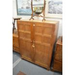 A 1930's oak small two door compactum in the manner of a Cotswold school.