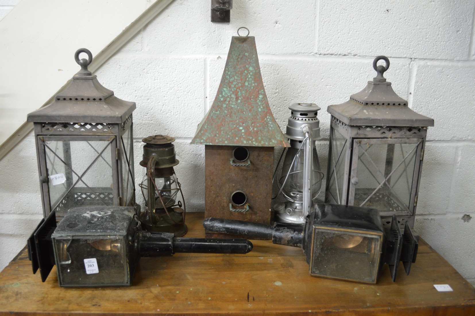 A pair of candle lanterns, an unusual copper roofed bird box and items.