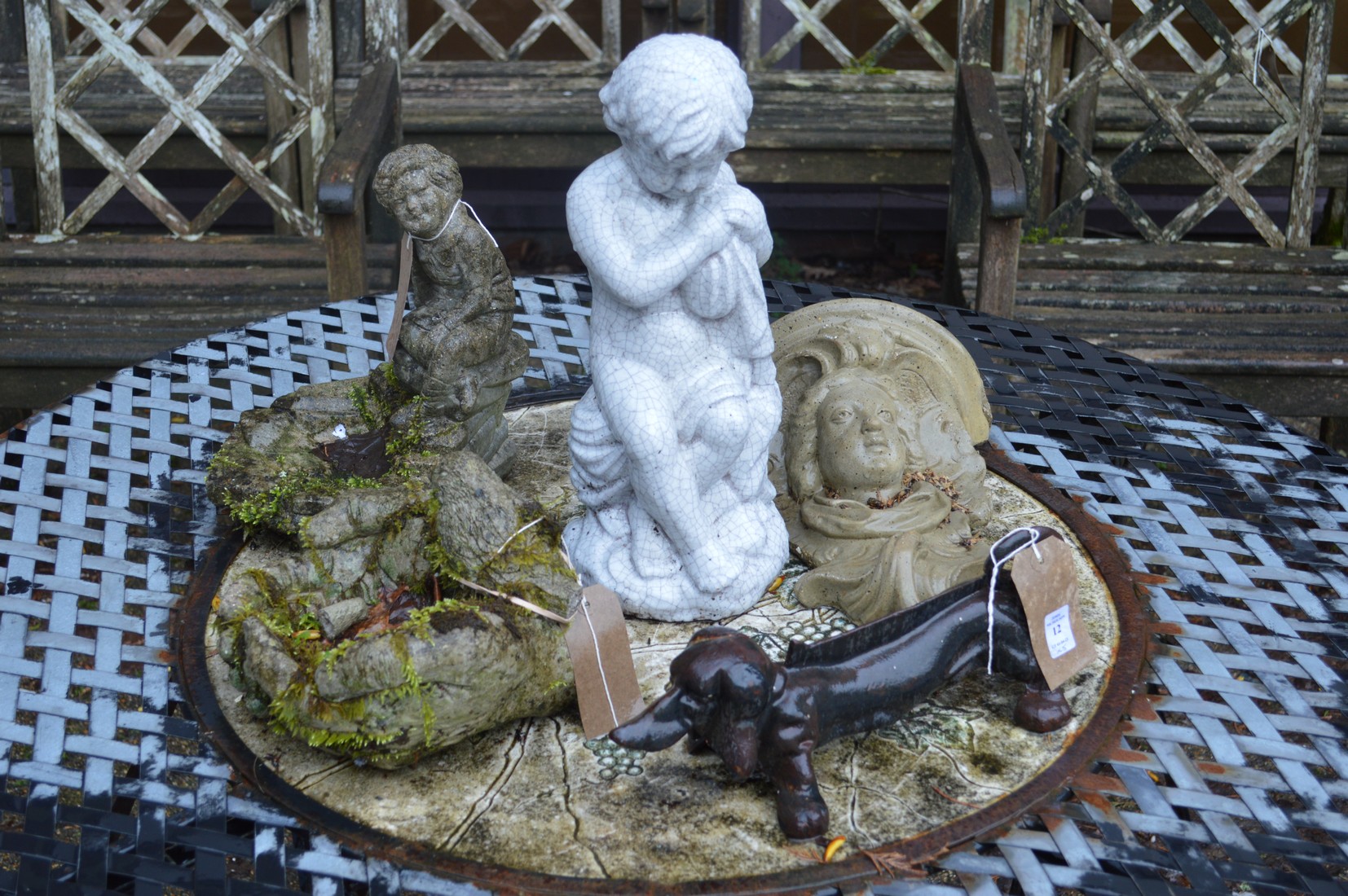 A dog shaped cast iron boot scraper and various garden ornaments.