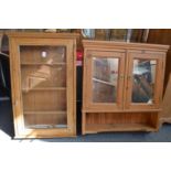 A small pine hanging cabinet with glazed door together with a pine bathroom cabinet.