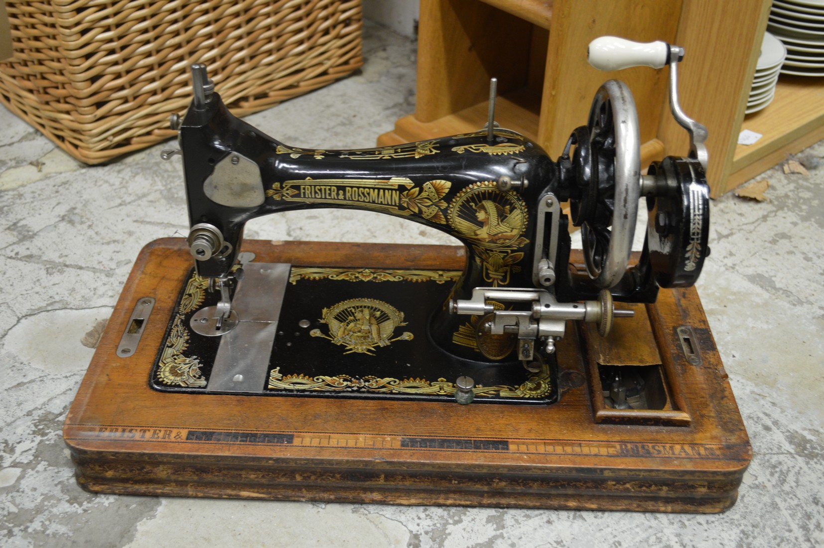 A narrow oak bookcase or CD rack and a sewing machine.