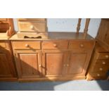 A pine sideboard with three drawers and three cupboard doors.