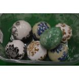 Six decorative porcelain balls and a hardstone egg.