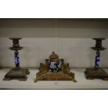 A brass and porcelain three piece desk set comprising: inkwell and pair of candlesticks.