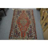 A small Persian rug with geometric decoration 124cm x 76cm.