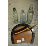 A horseshoe shaped crumb tray and brush and three old bottles.
