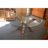 A stylish circular glass top coffee table on chrome support.
