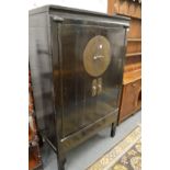 A Chinese black lacquer two door wardrobe with fitted interior.