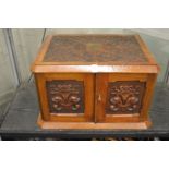 A very good Victorian carved walnut two door table top canteen, the pair of doors enclosing four