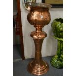 An Art Nouveau style copper jardiniere with stand.