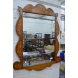 A marquetry inlaid mahogany mirror with shaped frame.