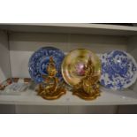 Three decorative plates, a pair of carved and gilded wall brackets and a porcelain ashtray.