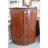 A George III mahogany bow front hanging corner cupboard.