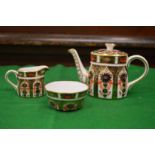 A Royal Crown Derby imari pattern miniature teapot, milk jug and sugar bowl together with a Royal