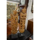 A pair of Thai carved wood figures on stand.