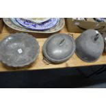A pewter dish and similar items.