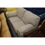A pale grey upholstered two seater leather settee.