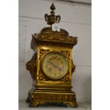 An ornate brass mantle clock.