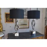 A pair of stylish chrome plated table lamps.