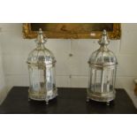 A pair of silvered metal lanterns.