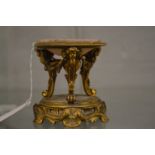 An ormolu miniature brasier or oil burner with associated alabaster dish.