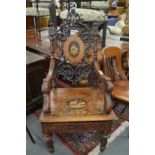 An unusual, rare 'Black Forest' carved and inlaid musical armchair.