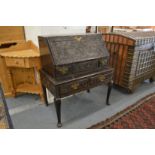 An 18th century carved oak bureau on stand.