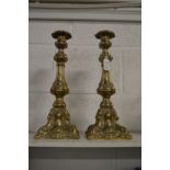 A pair of ornate cast brass candlesticks.