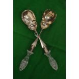 A pair of silver plated salad servers with cut glass handles.