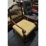 A walnut framed open armchair with canework back and seat with upholstered cushion.