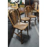 A pair of wheelback dining chairs and a bentwood chair.