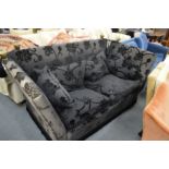 A large Knoll style two seater settee upholstered in a black fabric with cut velour detail.