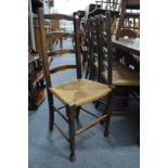 A set of four oak ladderback dining chairs.