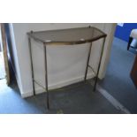 A glass and brass console table.