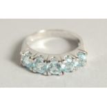 A SILVER BLUE TOPAZ HALF ETERNITY RING.