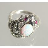 A SILVER OPAL AND RUBY SNAKE RING.