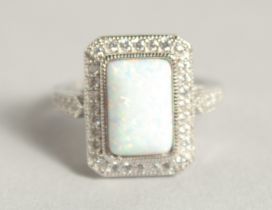 A SILVER CUBIC ZIRCONIA AND OPAL DRESS RING.