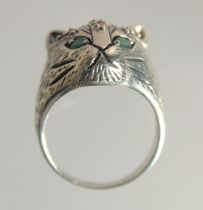 A SILVER RUBY AND EMERALD CATS FACE RING.