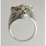 A SILVER RUBY AND EMERALD CATS FACE RING.