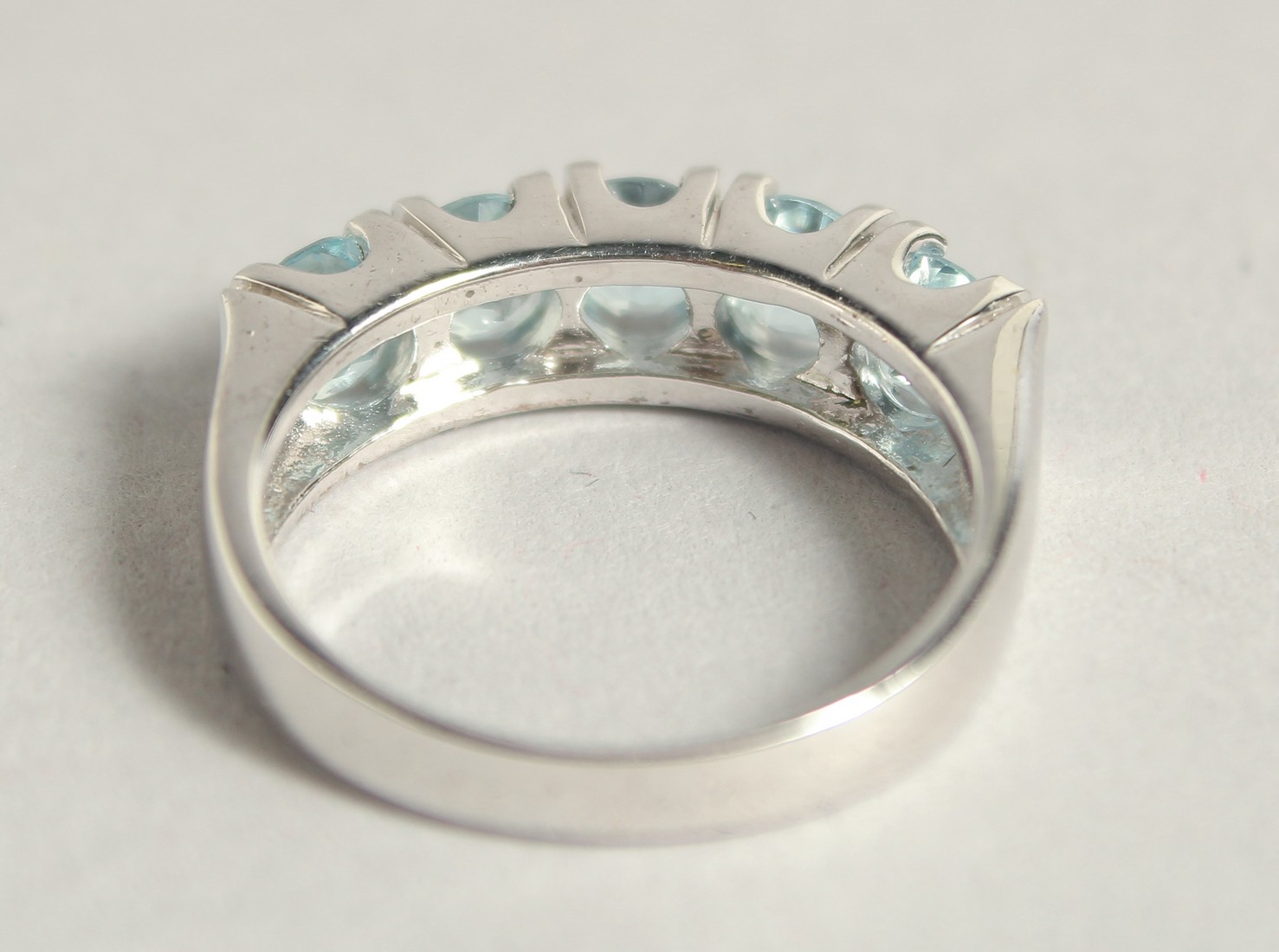 A SILVER BLUE TOPAZ HALF ETERNITY RING. - Image 2 of 3