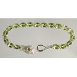 A SILVER PERIDOT SET SNAKE BANGLE.