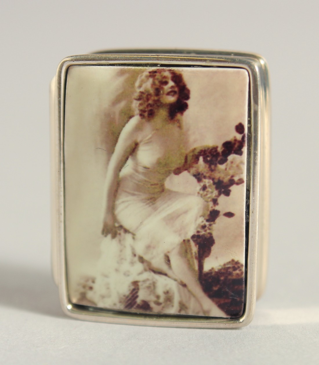 A SILVER AND ENAMEL NUDE PILL BOX, 1.25".